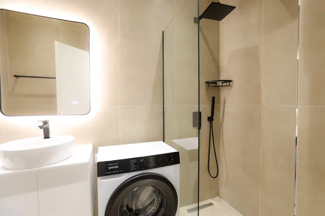 Bad mit Dusche, Waschbecken und Waschmaschine